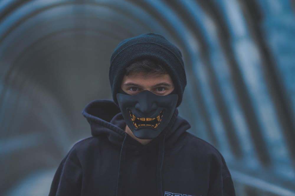 a man wearing a black mask and a black hoodie