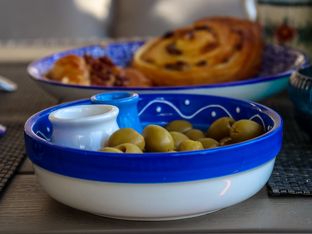 a bowl of olives and a bowl of bread on a table