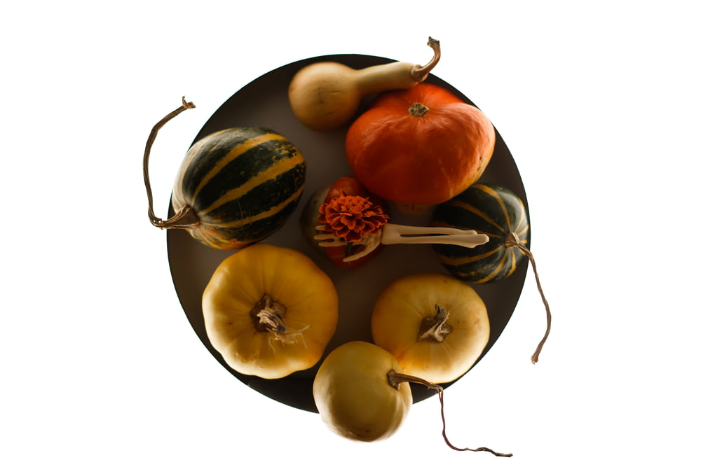 a plate of squash and gourds on a white background