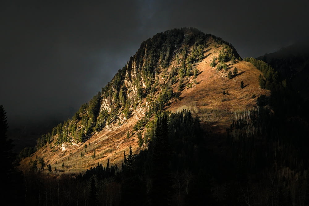 a mountain with a dark sky in the background