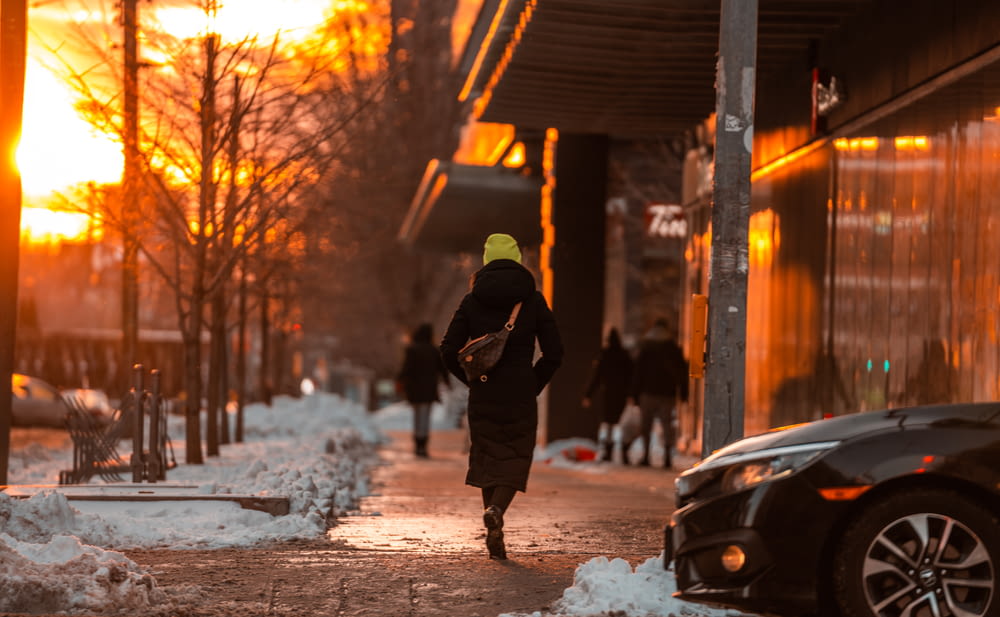 Eine Person, die im Schnee einen Bürgersteig entlang geht