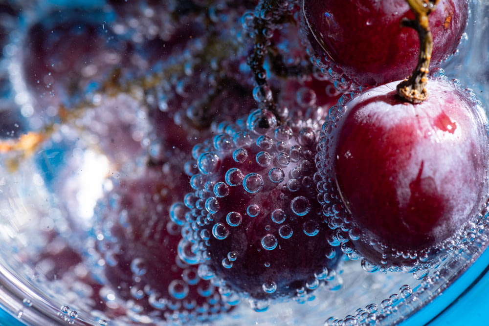 a close up of a bowl of cherries in water
