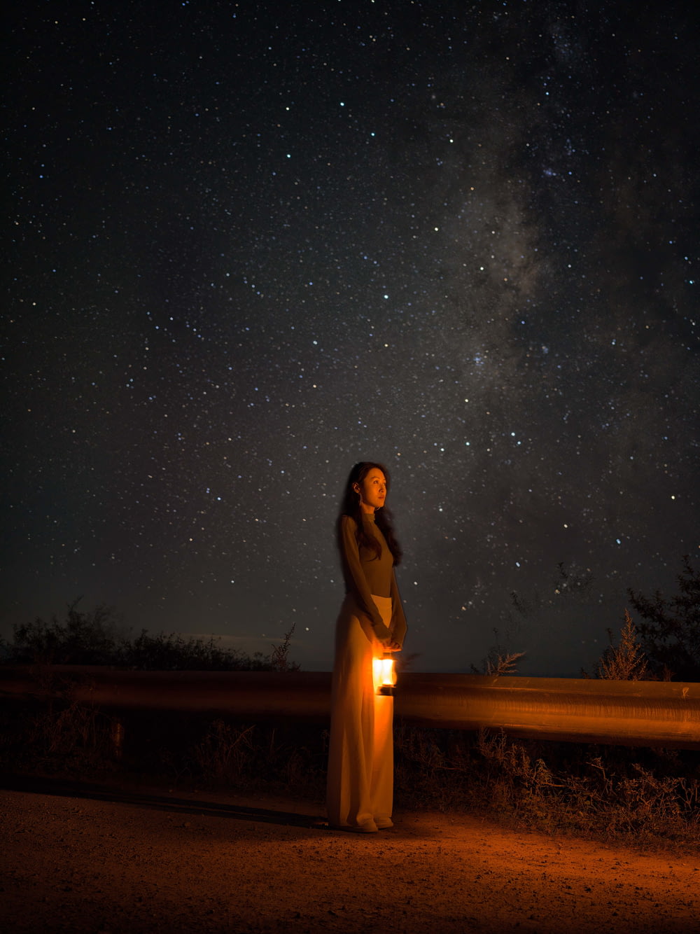 a woman standing in front of a night sky