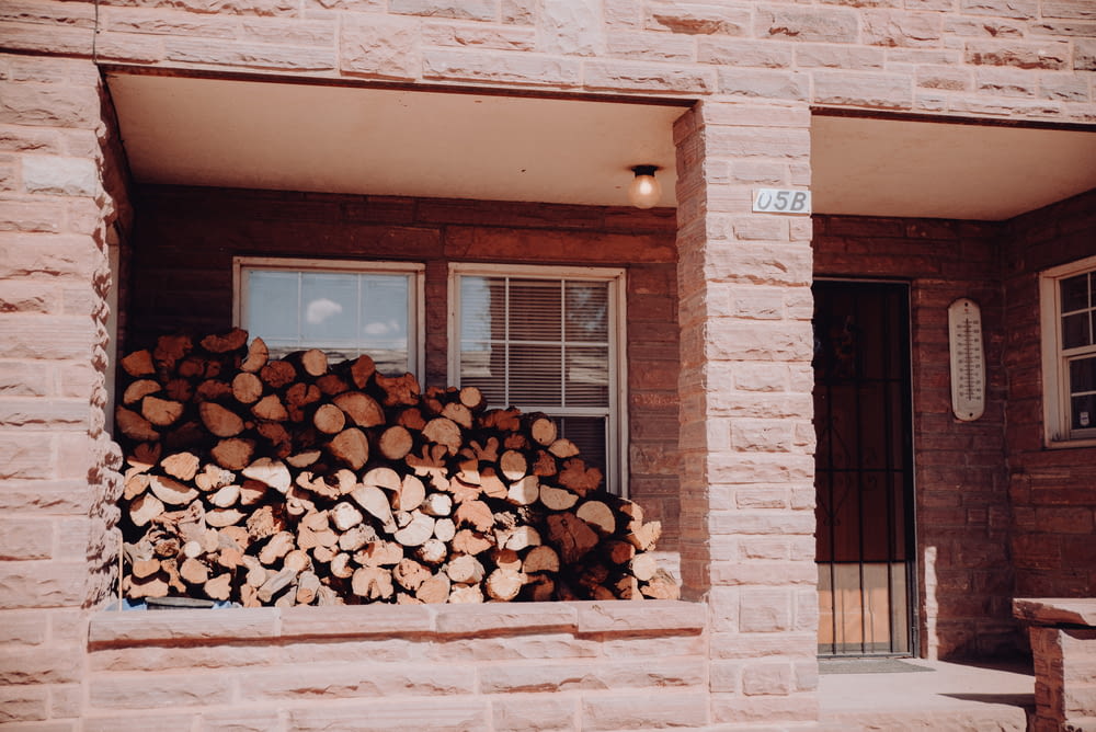 a stack of logs sitting in front of a window