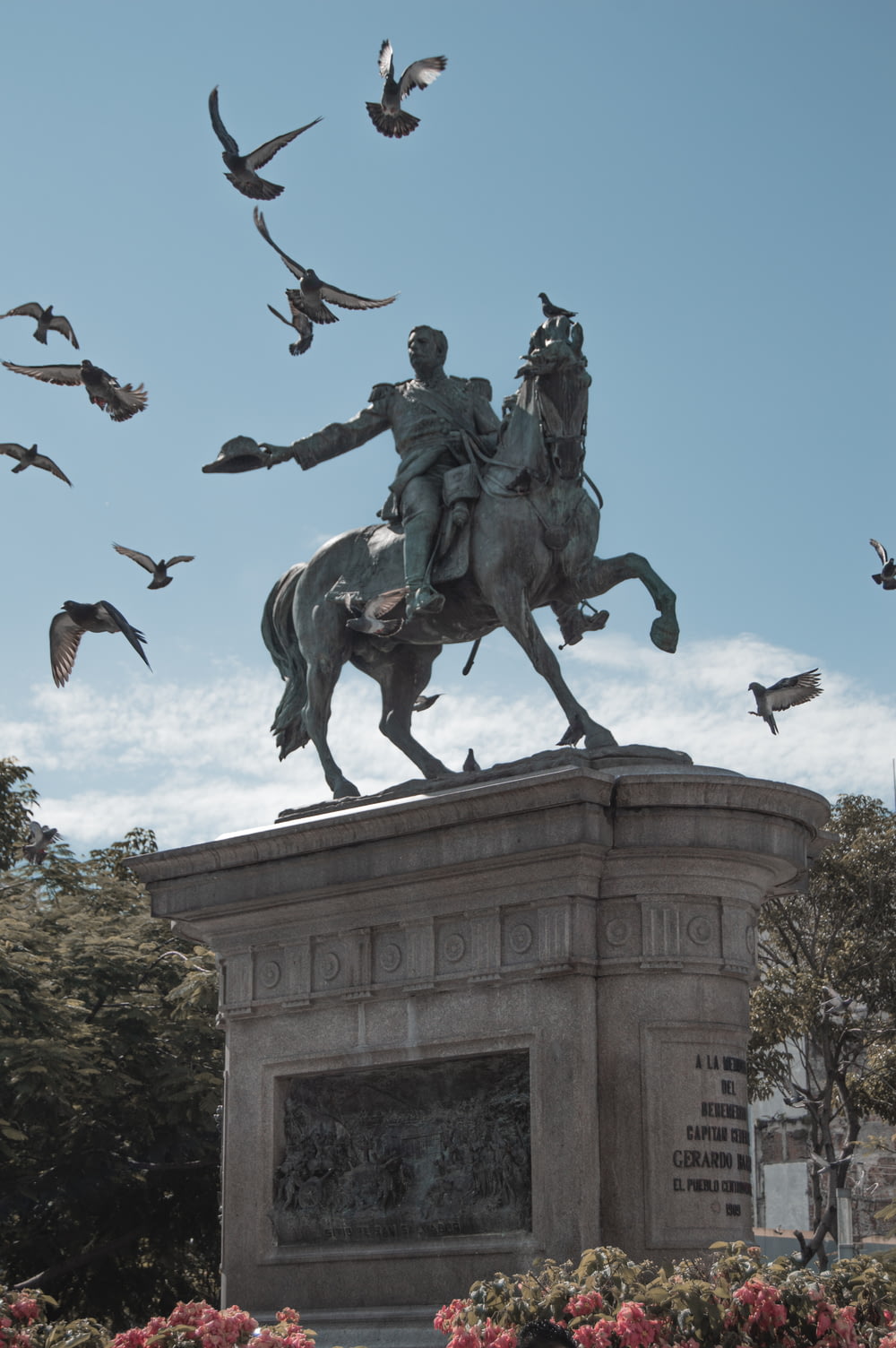 a statue of a man on a horse surrounded by birds