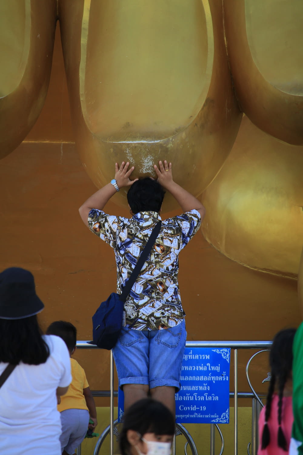 a man standing in front of a giant golden object
