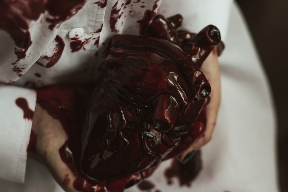 a person holding a bleeding heart in their hands