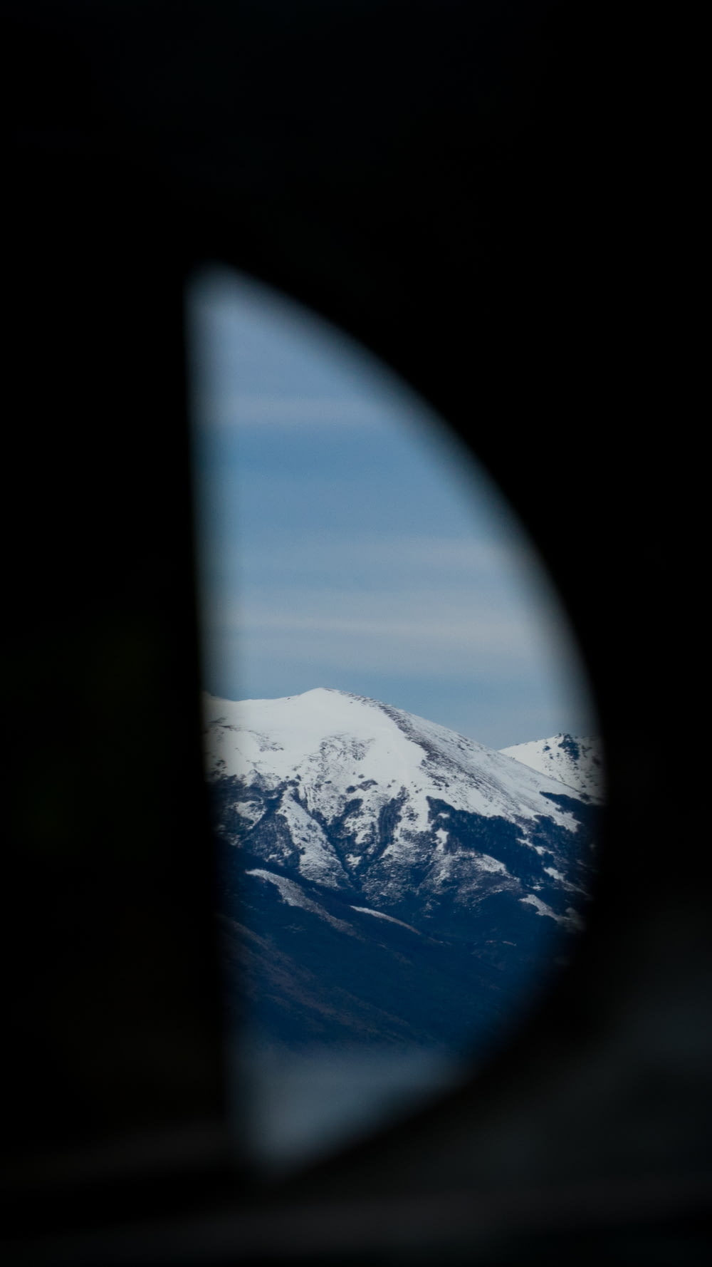a view of a snowy mountain from a plane window