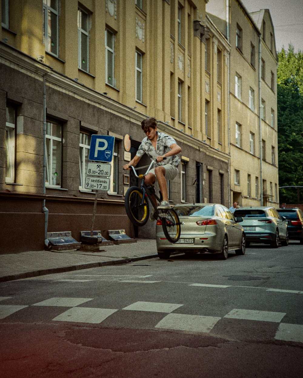 um homem andando de bicicleta por uma rua ao lado de um carro