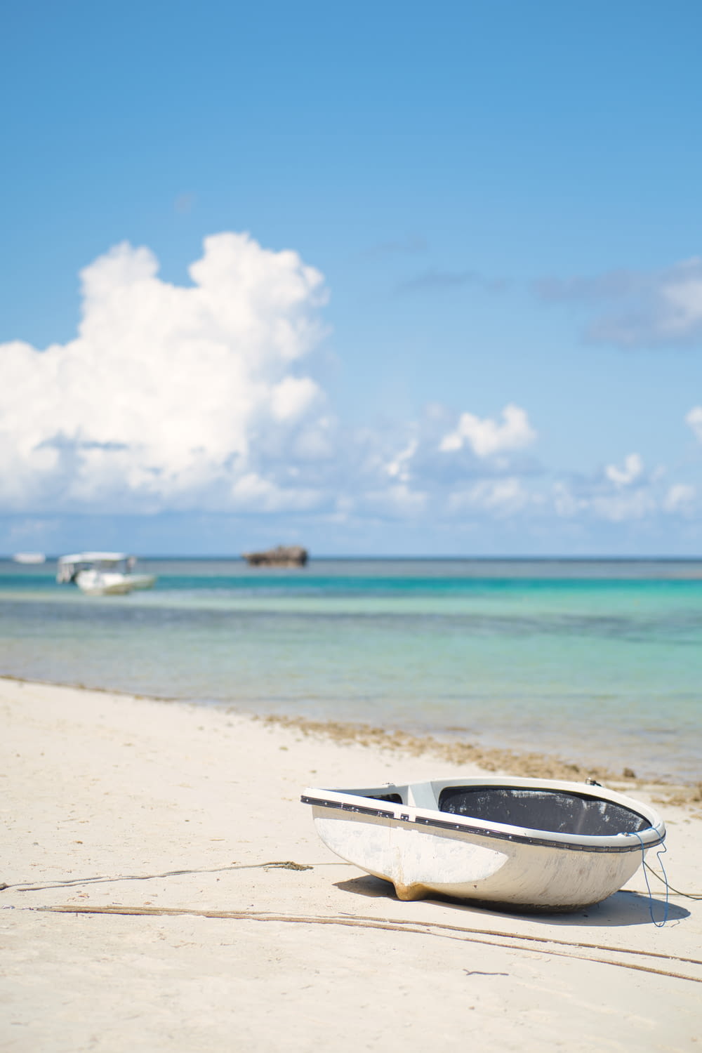 a small boat sitting on top of a sandy beach