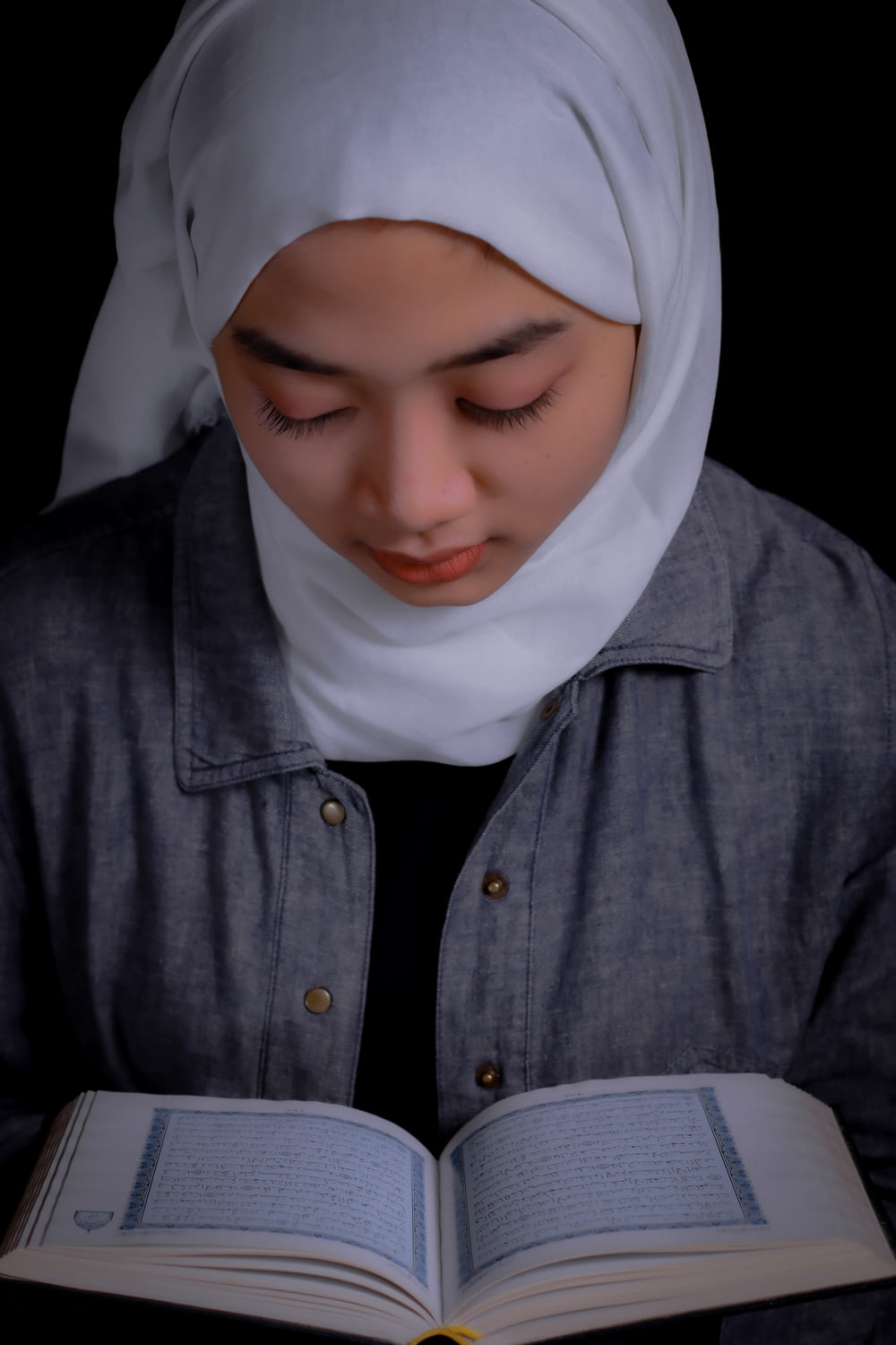 uma mulher em um hijab lendo um livro