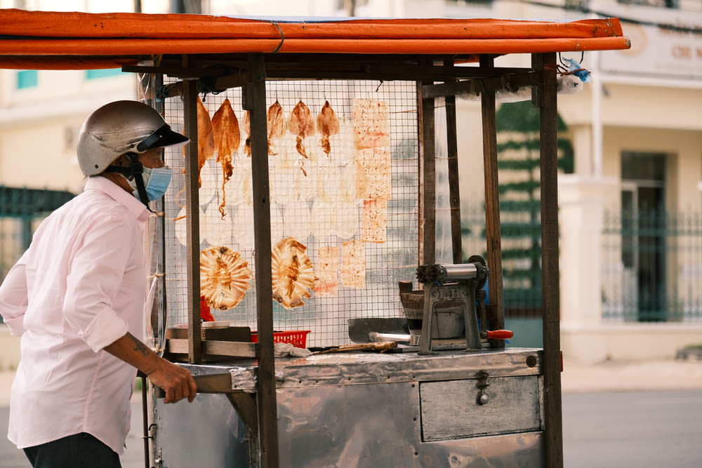 Ein Mann mit Gesichtsmaske steht neben einem Imbisswagen