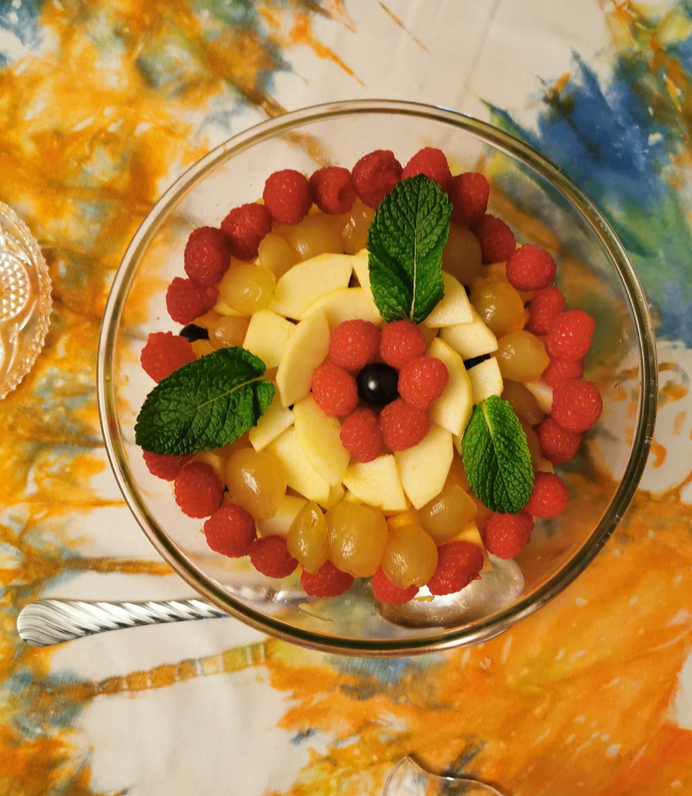 una ciotola di vetro piena di frutta sopra un tavolo