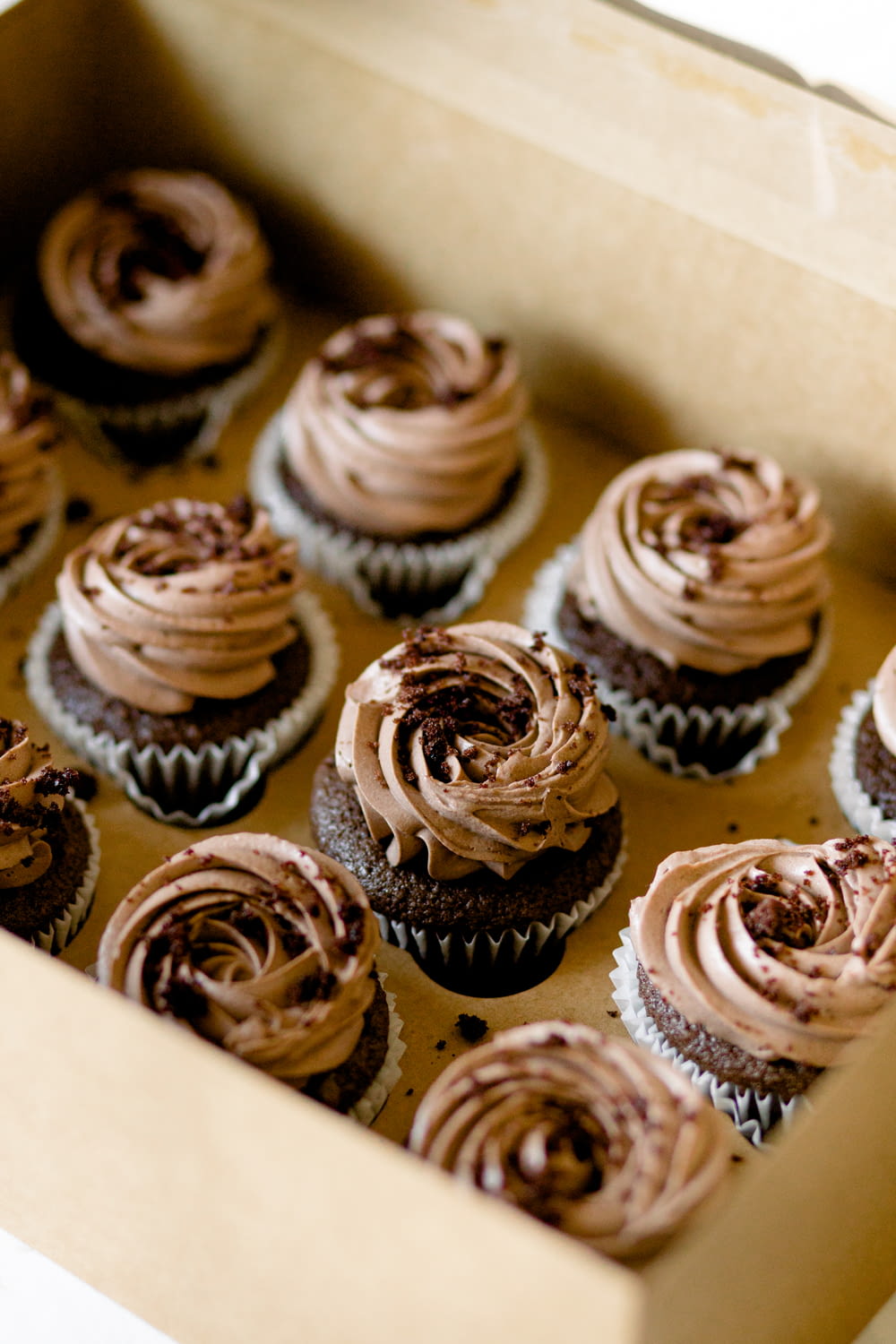a box full of chocolate cupcakes with frosting