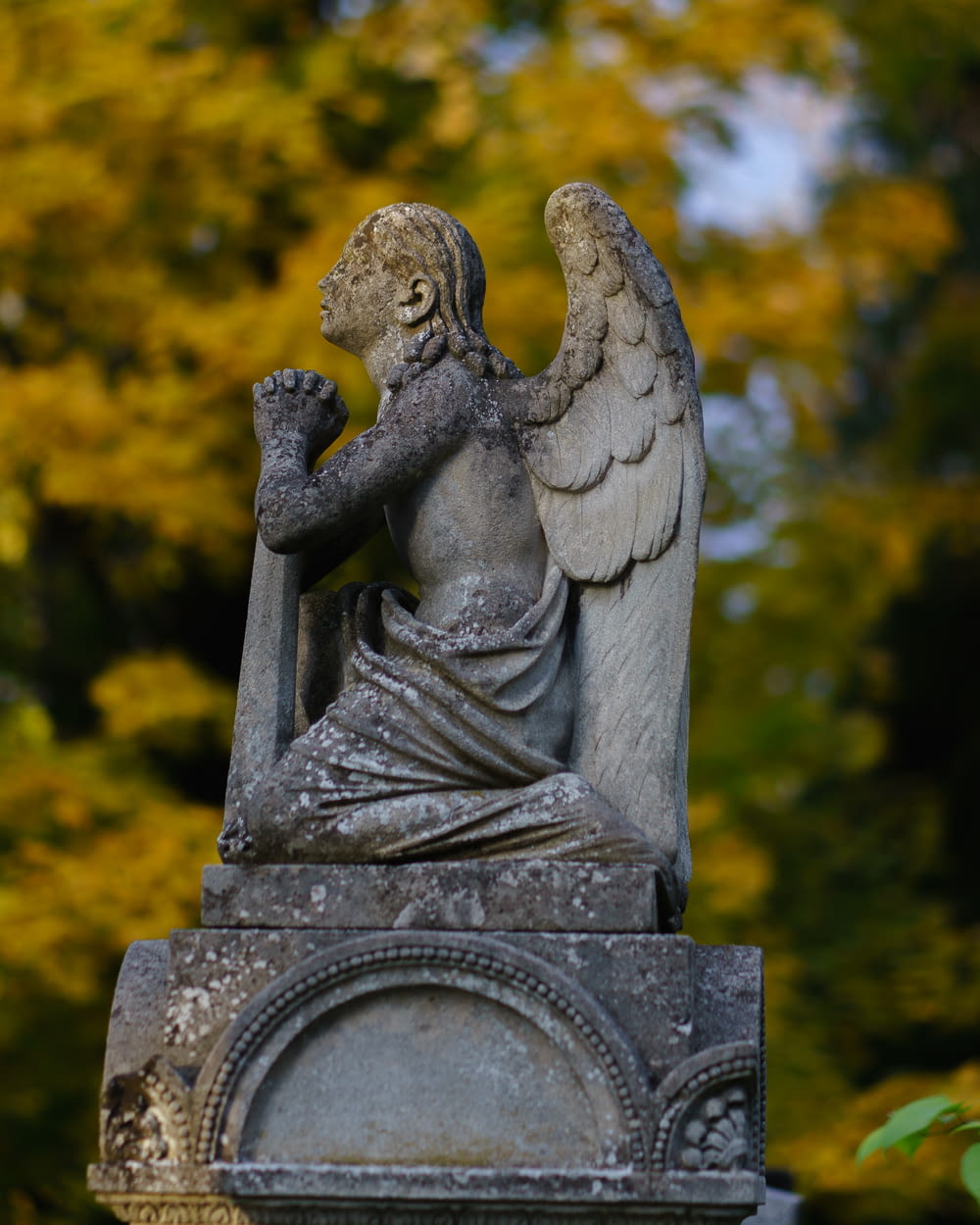 a statue of an angel sitting on top of a grave