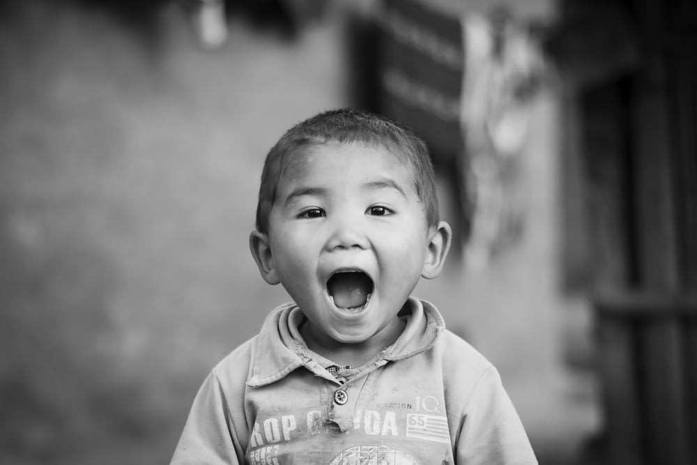 a young boy making a funny face with his mouth open