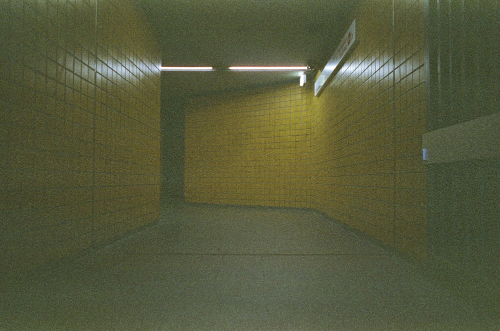 a dimly lit hallway with yellow brick walls