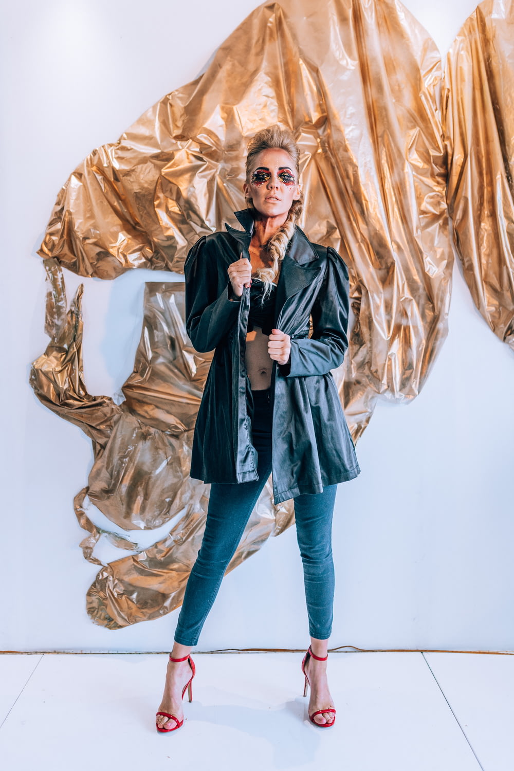 a woman standing in front of a gold wall