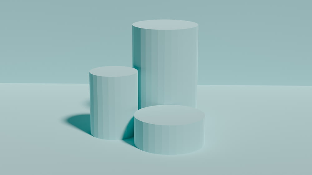 three white cylindrical objects on a light blue background