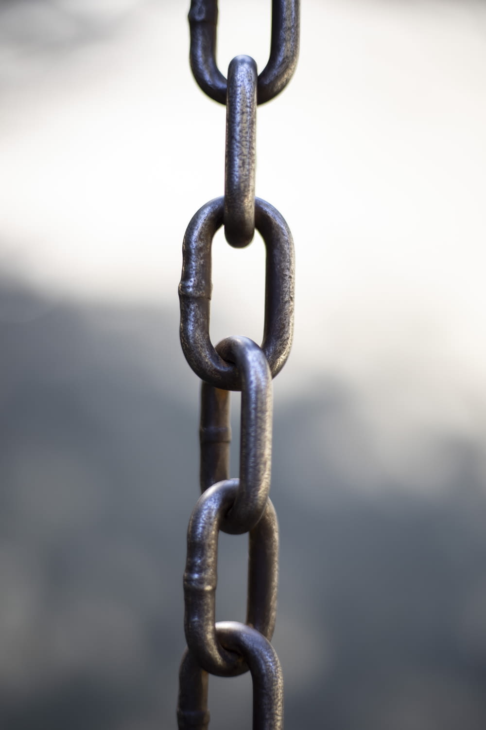 a close up of a chain with a sky in the background