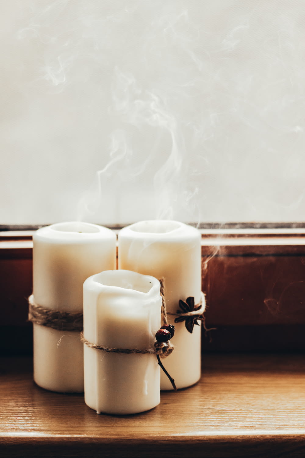 a group of white candles sitting on top of a wooden table