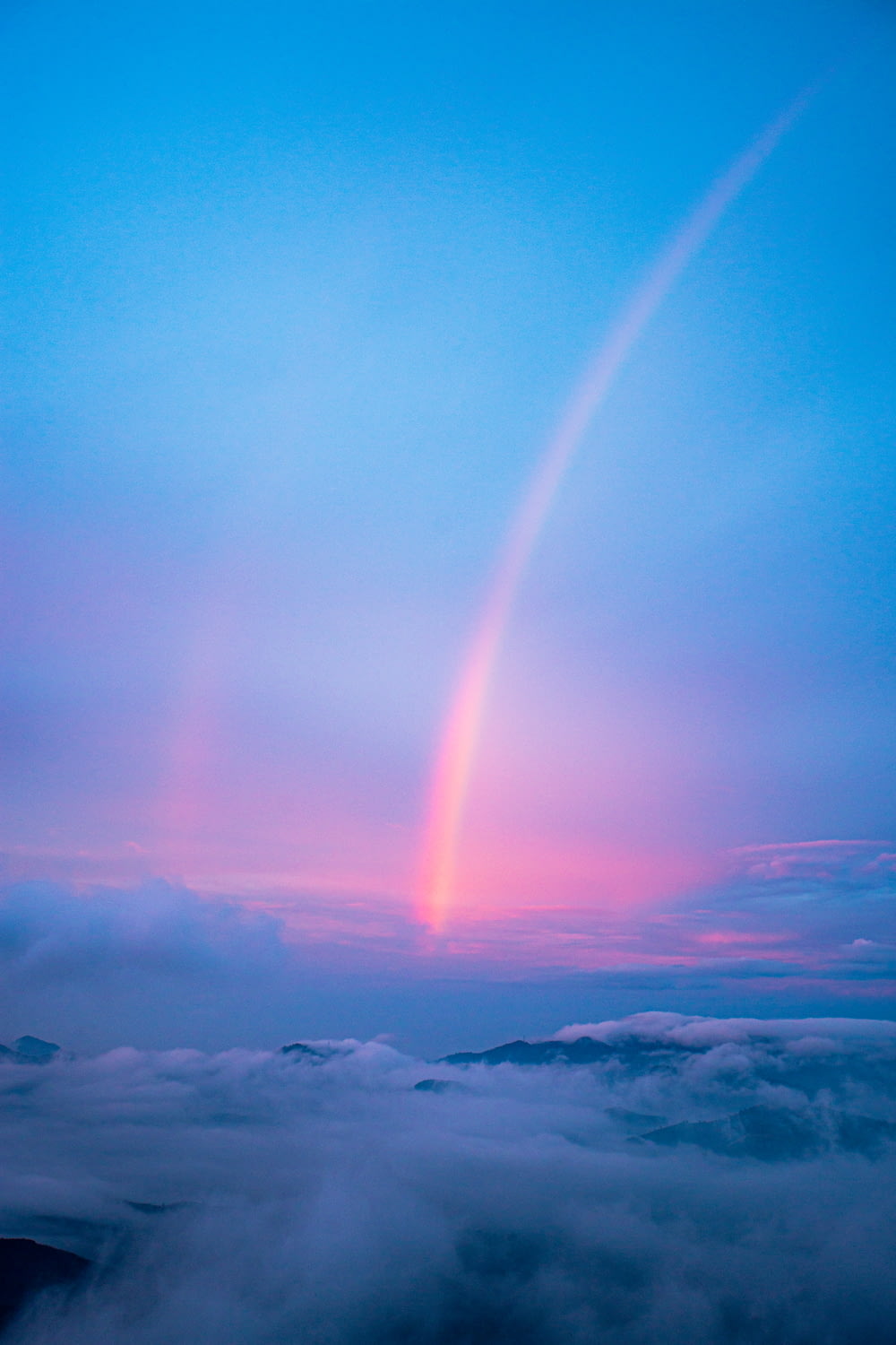 a rainbow in the sky above the clouds