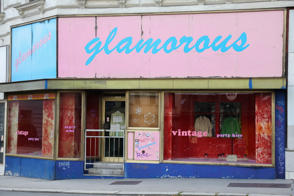 a store front with a pink and blue sign on it