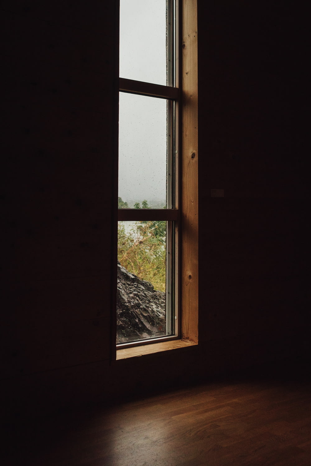 a window in a dark room with a view of a field