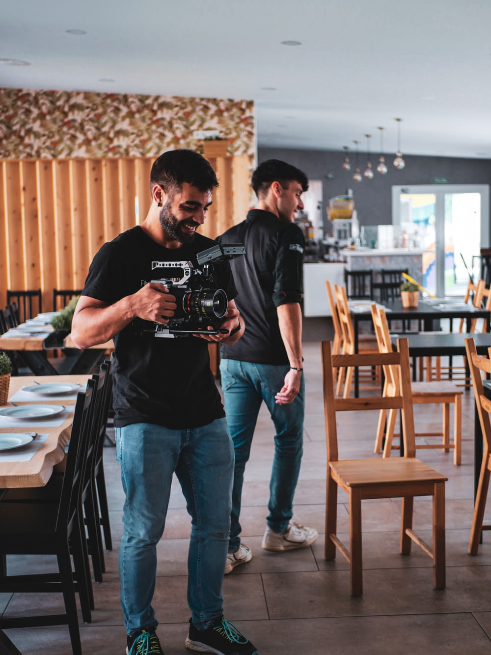 two men standing in a restaurant looking at a camera