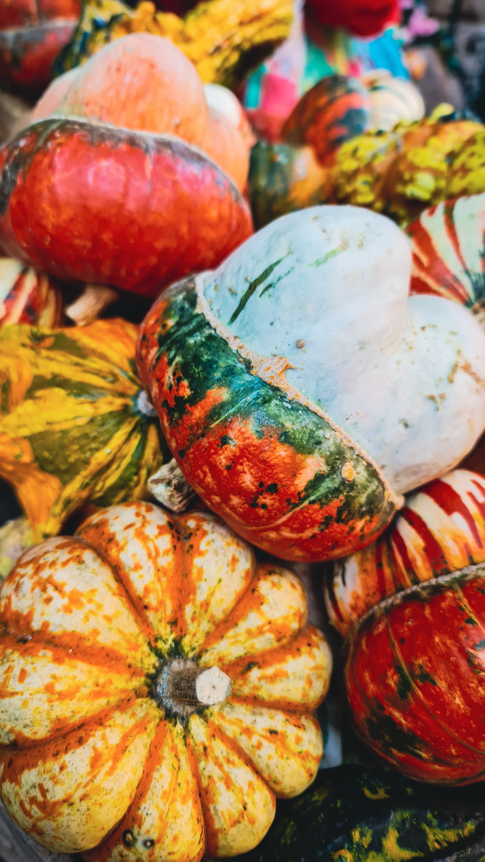 a pile of colorful pumpkins sitting on top of each other