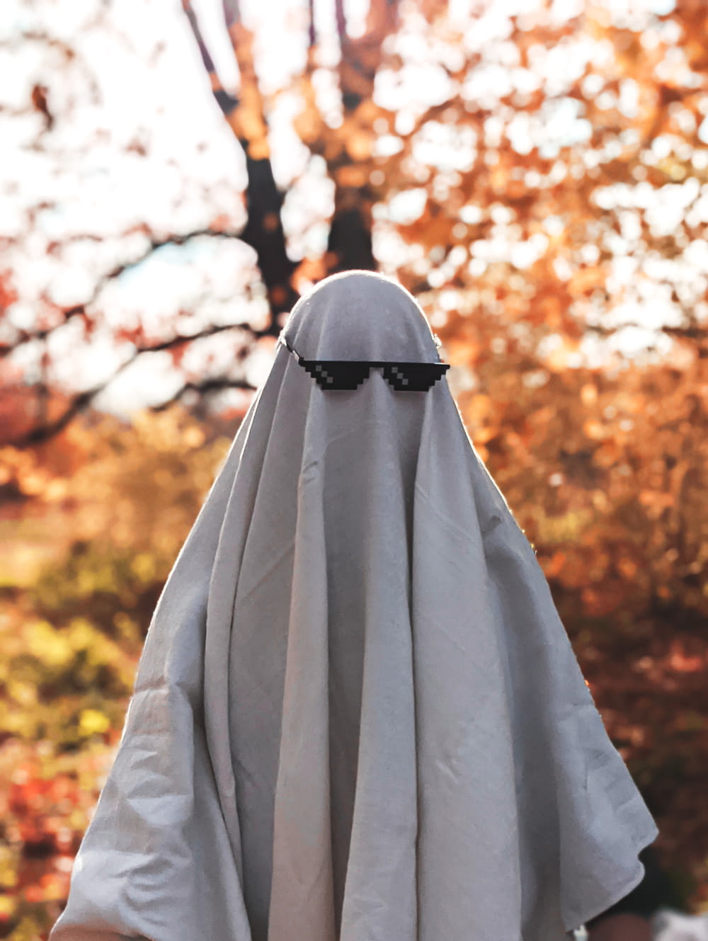 a person wearing a white cloak and sunglasses