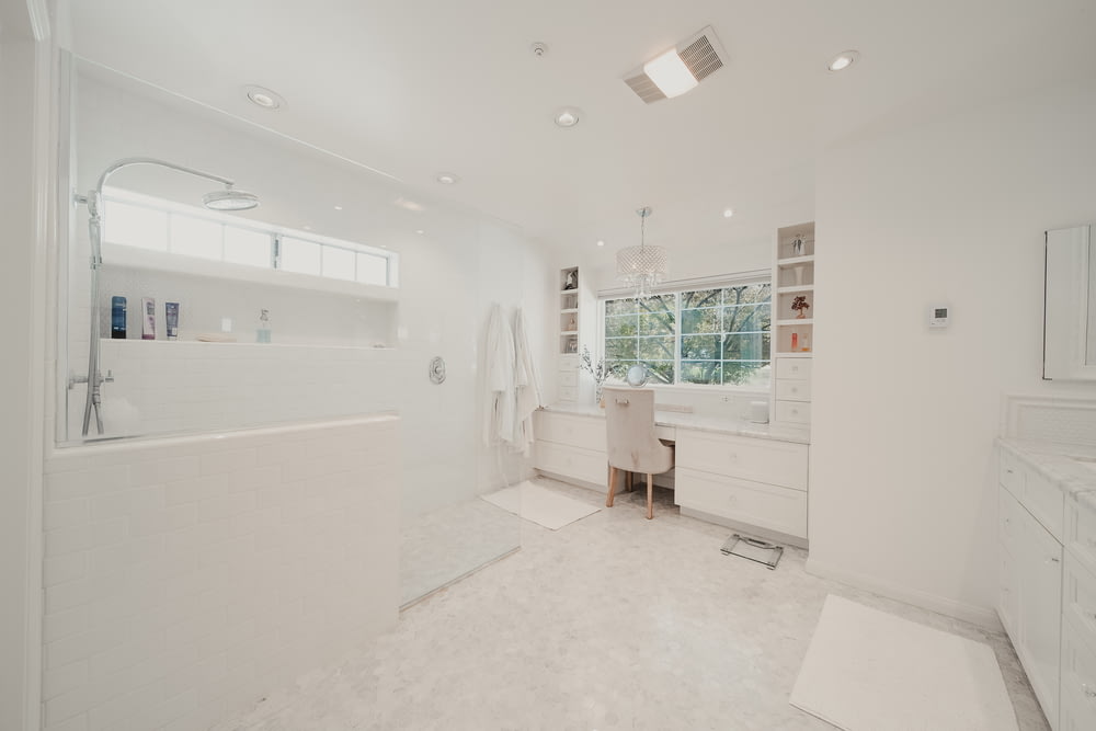 a large white bathroom with a tub and sink