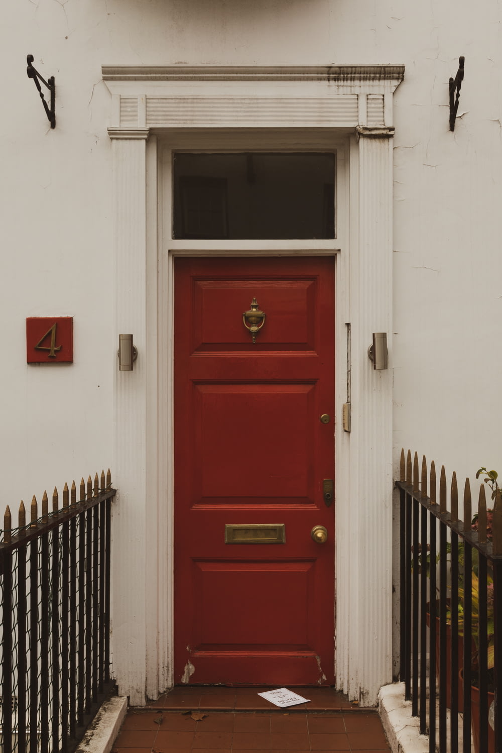a red door with a clock above it