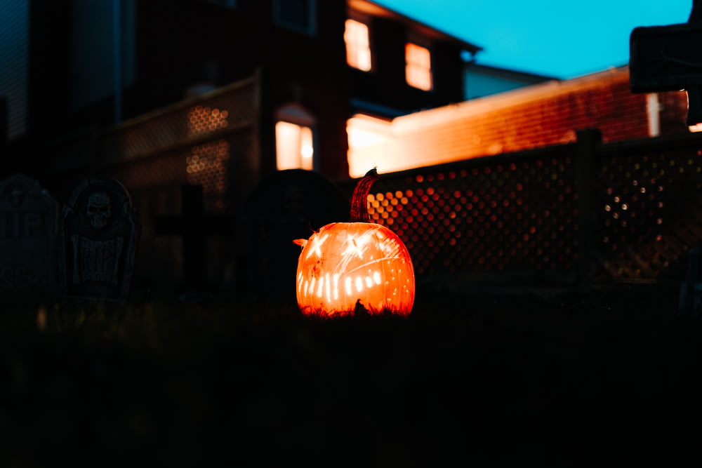 a carved pumpkin sitting on the ground in front of a house