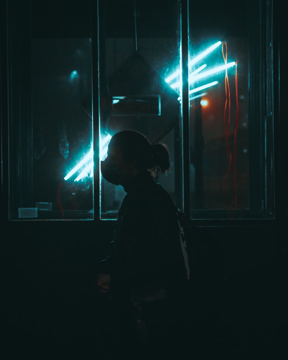 a person standing in front of a window at night