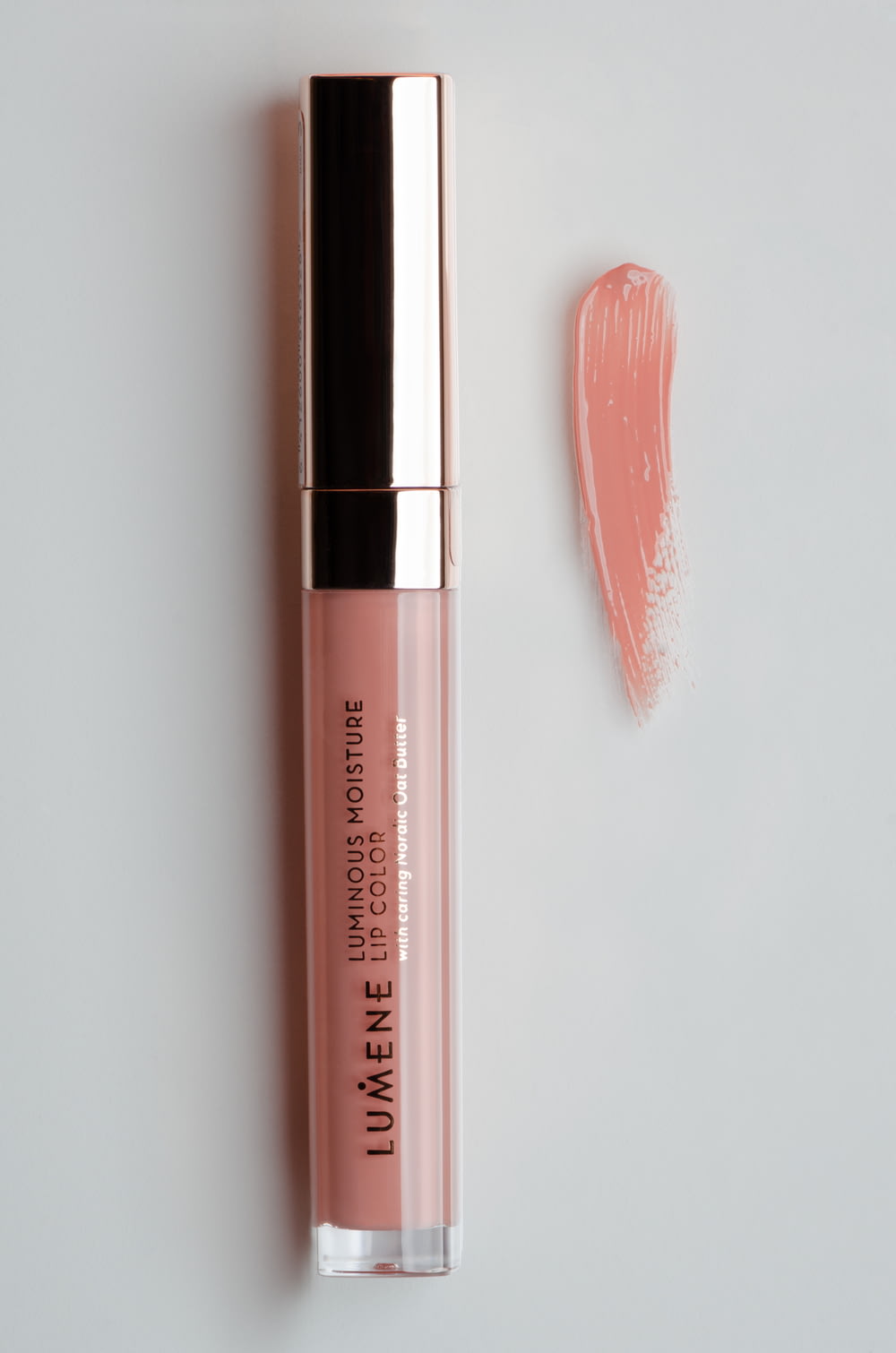 a pink lip gloss next to a lipstick tube