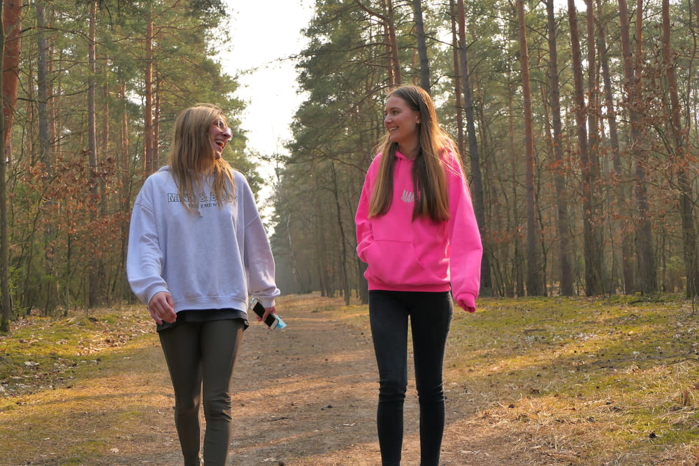 two girls walking down a path in the woods