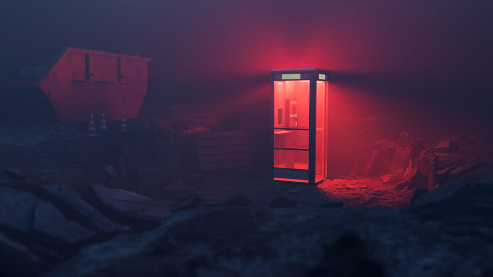 a red light shines on a refrigerator in a dark room