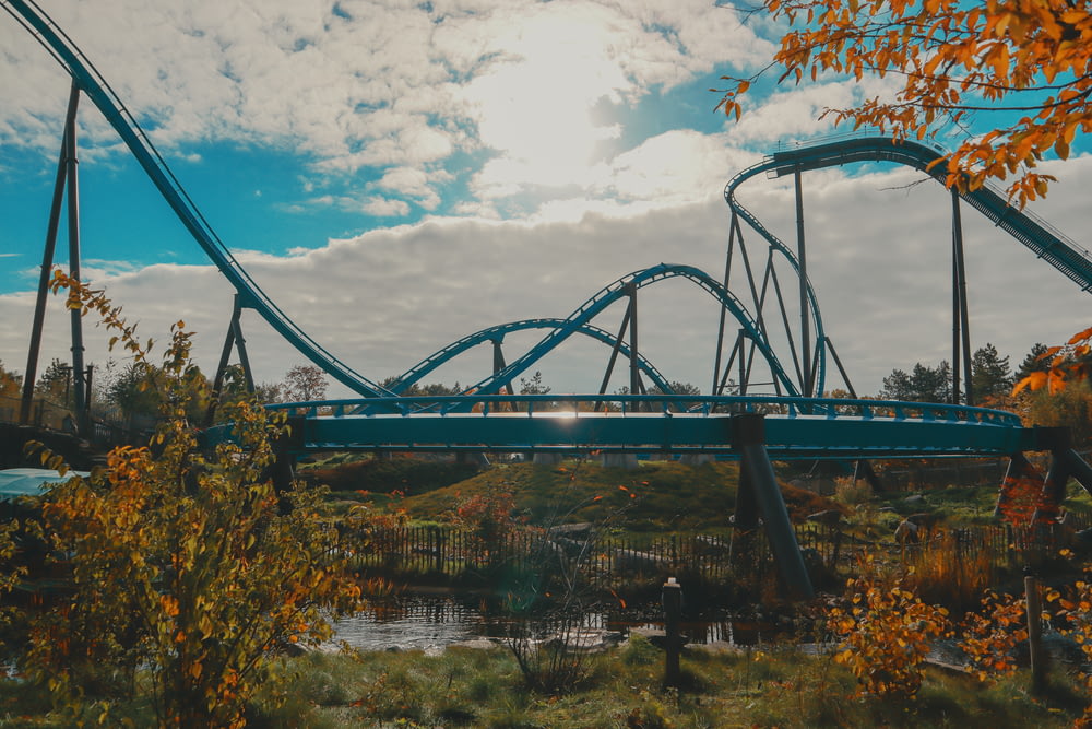a roller coaster going over a river in a park