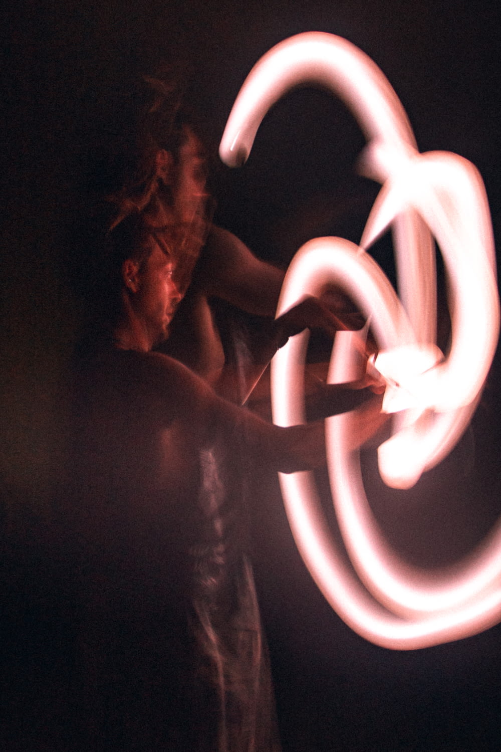 a woman is spinning a circular object in the dark