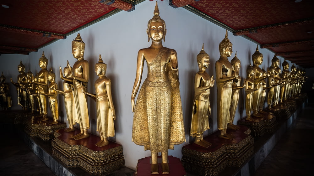 隣り合って座っている黄金の仏像の列