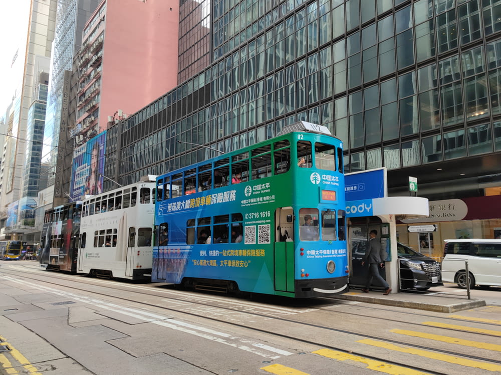 Ein blau-weißer Doppeldeckerbus auf einer Stadtstraße
