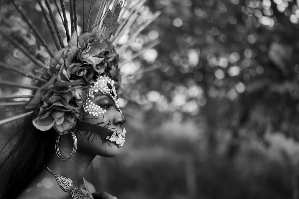 a woman wearing a mask with feathers on her head