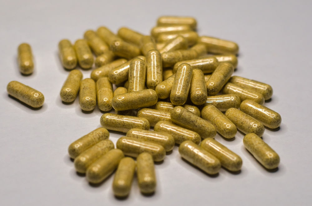 a pile of yellow pills sitting on top of a table