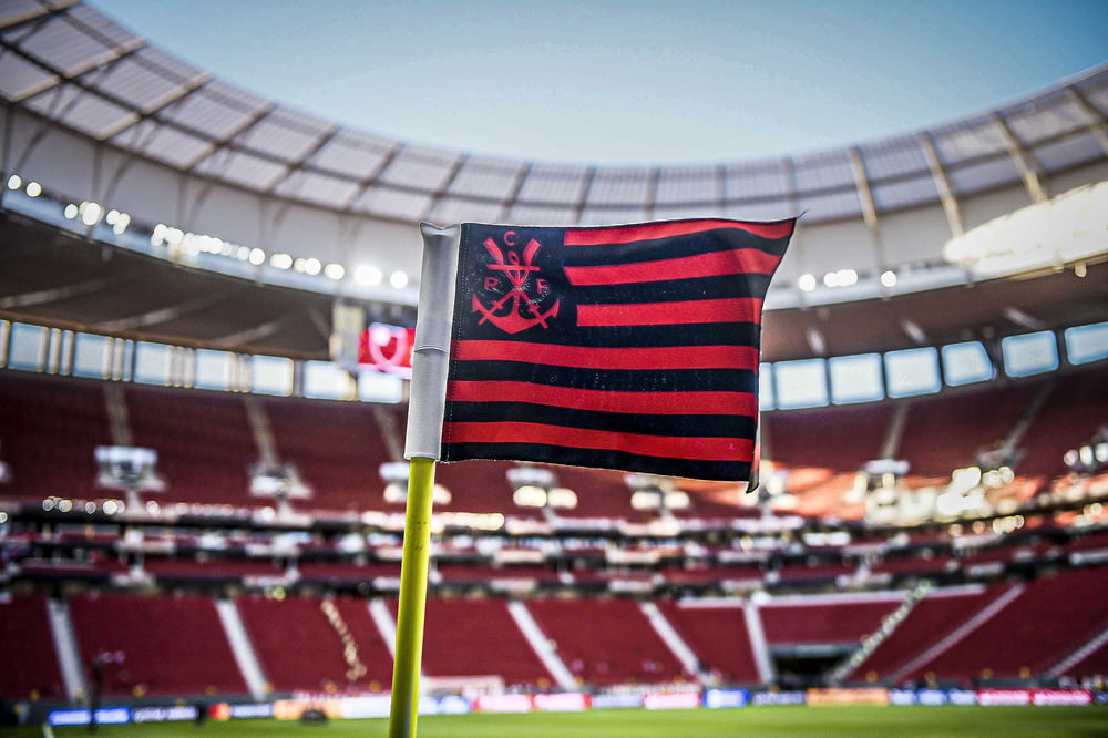a red and black striped flag in a stadium