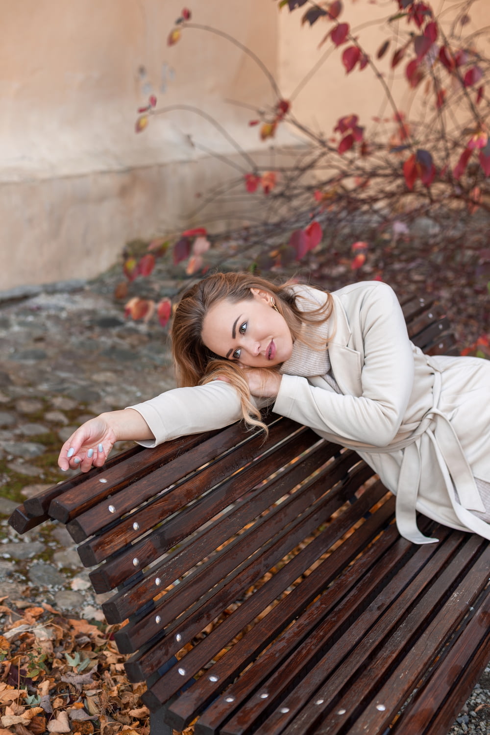 a woman sitting on top of a wooden bench