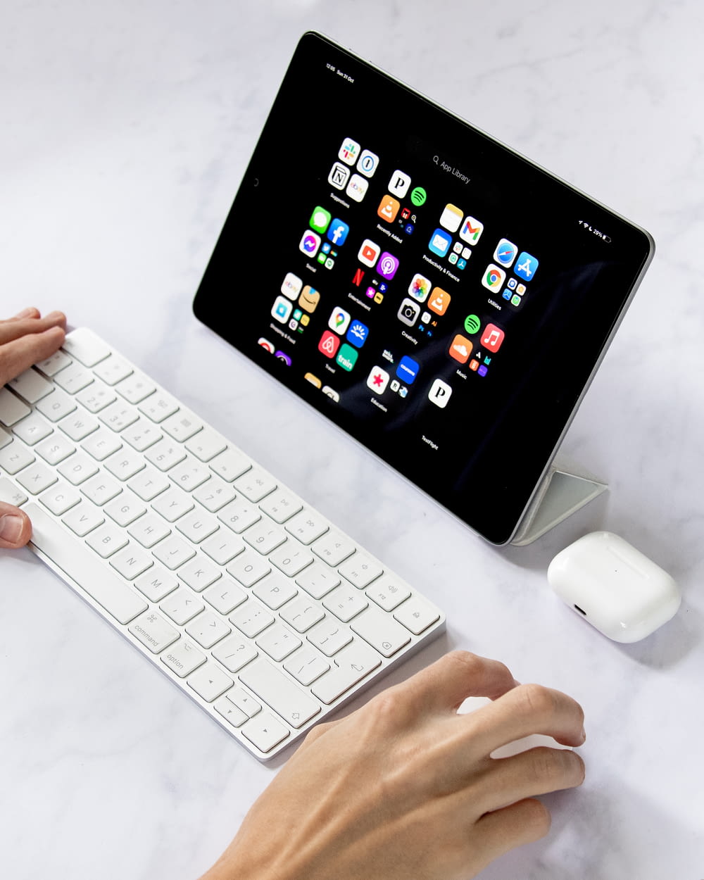 une personne tapant sur un clavier à côté d’une tablette