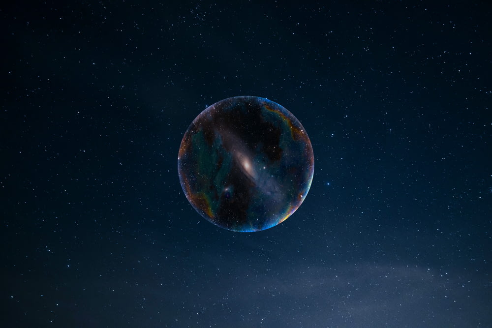 a large bubble floating in the air with stars in the background