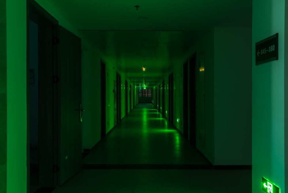 un lungo corridoio con luci verdi sulle pareti
