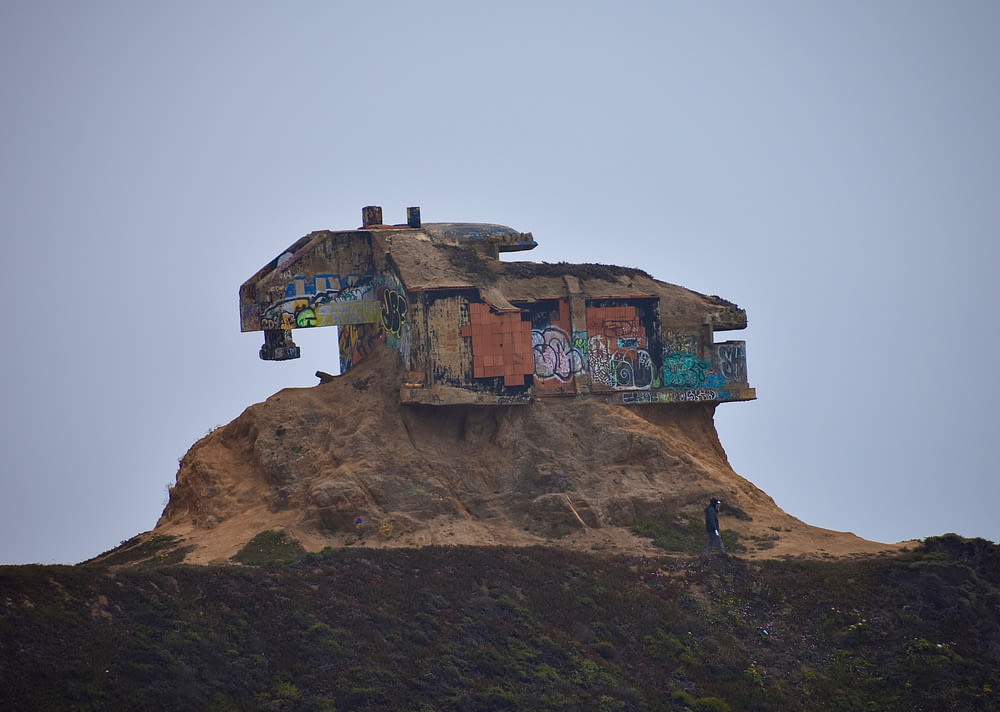a house on top of a hill covered in graffiti
